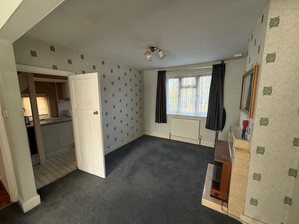 Lot: 226 - THREE-BEDROOM SEMI-DETACHED HOUSE FOR IMPROVEMENT - Dining area with fireplace, window and radiator with access to kitchen